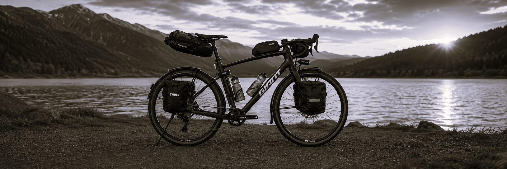 Bikepacking-Fahrrad am Bergsee im Sonnenuntergang